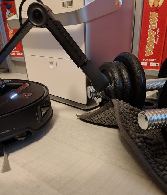 Robo trying to lift a rug with dumbbells on it