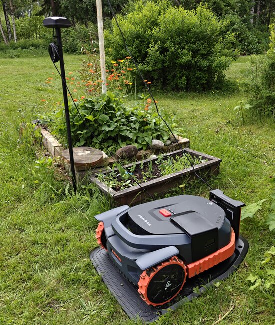 Segway Navimow X3 telakassa, satelliittivastaanotin kuvassa mukana