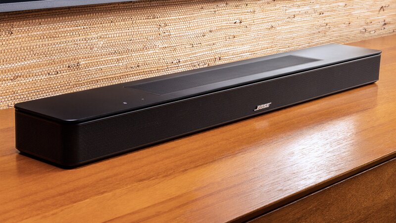 musta Bose Soundbar 600 kaiutin puisella tv-tasolla television alapuolella
