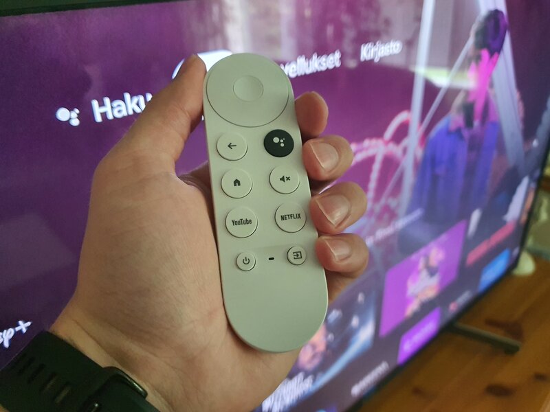 valkoinen Chromecast with Google TV kaukosäädin kädessä