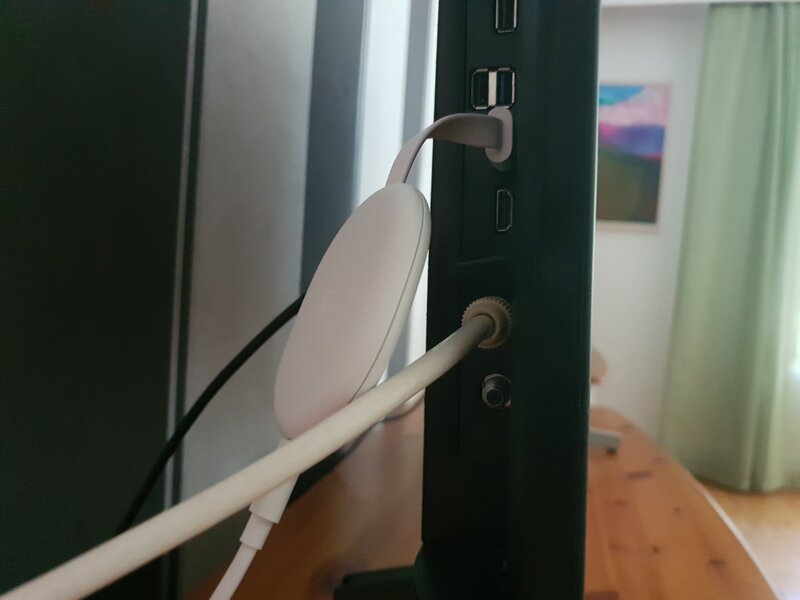 valkoinen Chromecast with Google TV kiinnitettynä television HDMI-porttiin