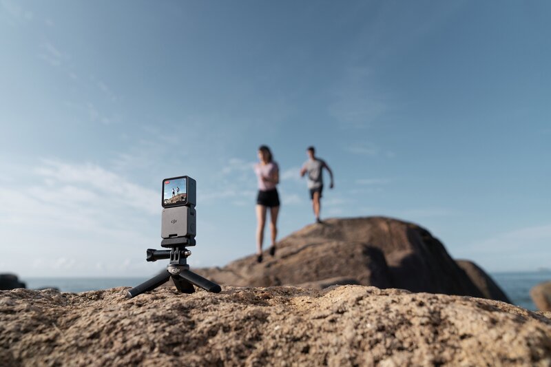 Action 2 kamera yhdessä näyttömoduulin kanssa kuvaamassa kalliolla juoksevia ihmisiä