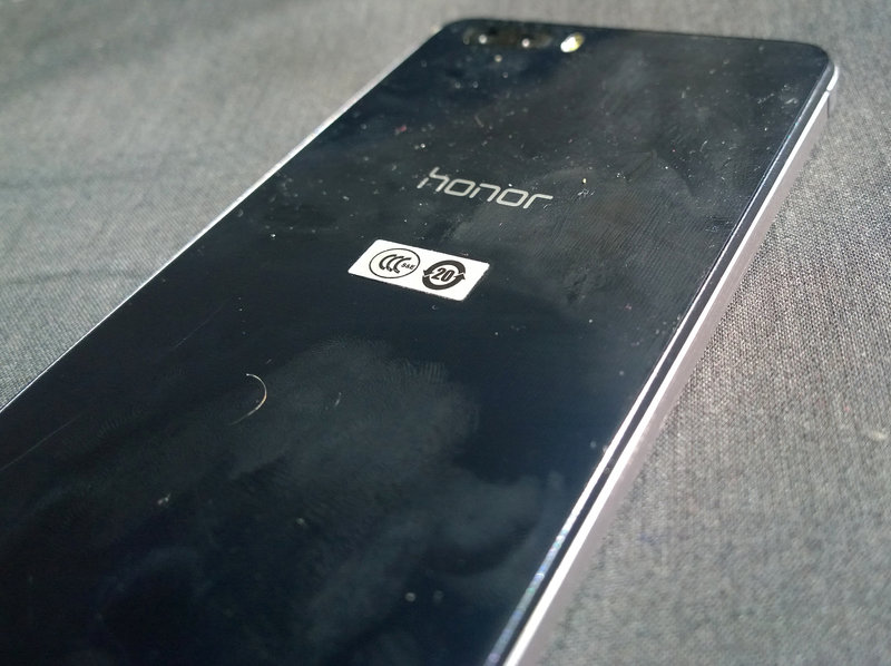 Huawei Honor 6+ - Sormenjälkiä takalasissa, tummempi kohta keskellä puhelinta on pyyhitty puhtaammaksi.