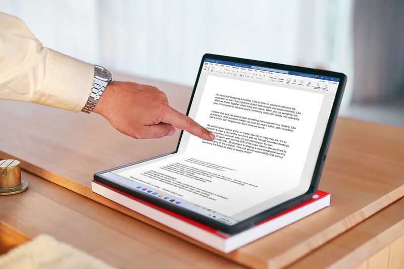 henkilö lukemassa tekstiä puoliksi taitetusta ThinkPad X1 Fold (2022) koneen näytöltä