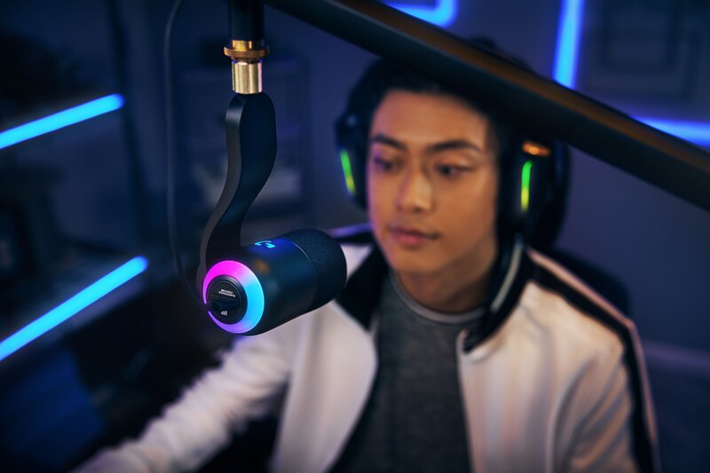 RGB-valaistuksella varustettu Logitech G Yeti GX mikrofoni telineessä miehen edessä