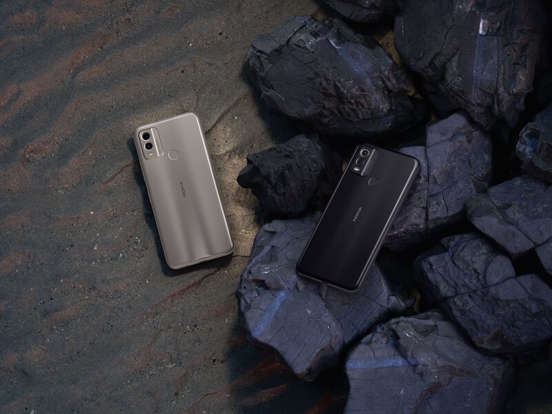 musta ja hiekanvärinen Nokia C22 kivisellä ja hiekkaisella maalla
