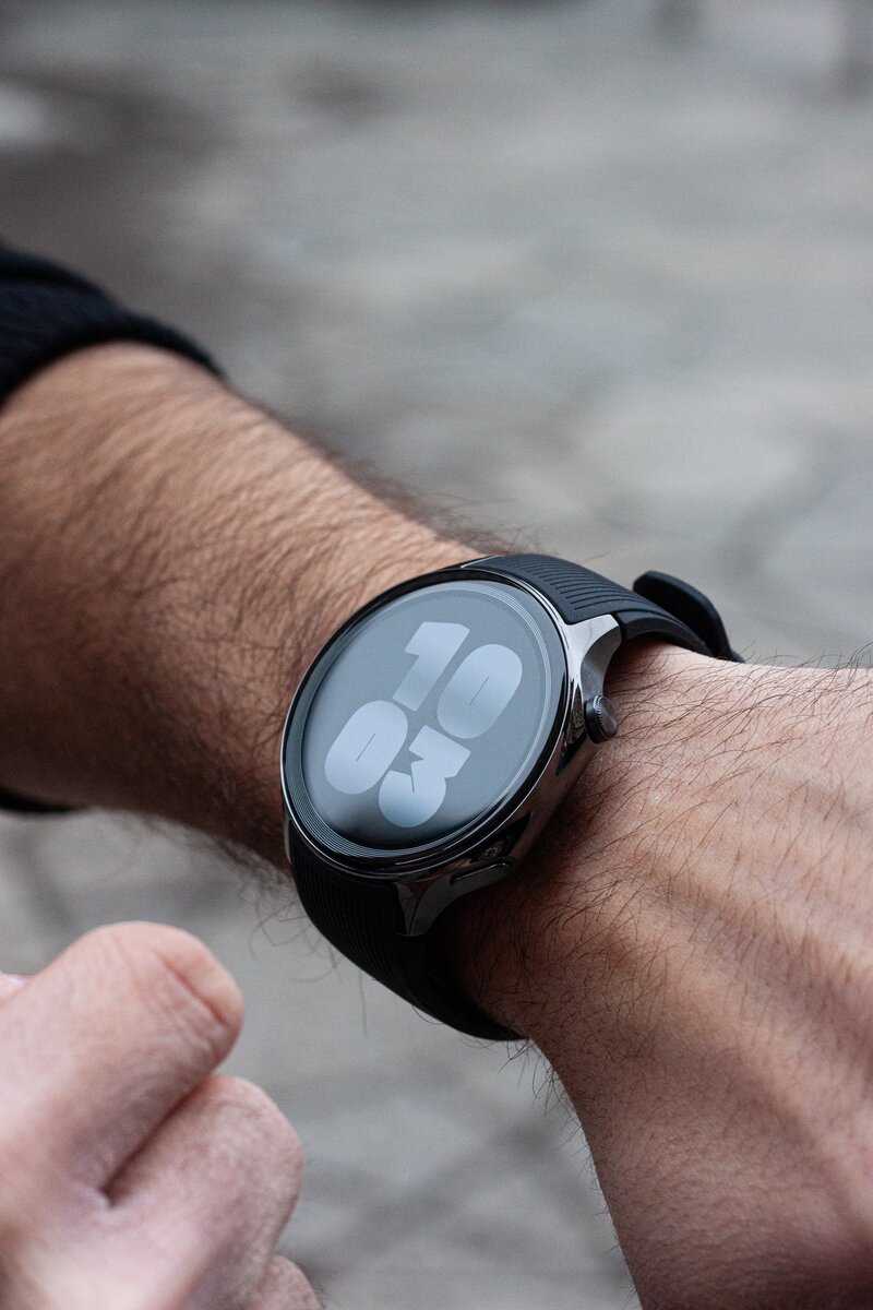 OnePlus Watch 2 älykello henkilön ranteessa. Kellon näytöllä näkyy aika