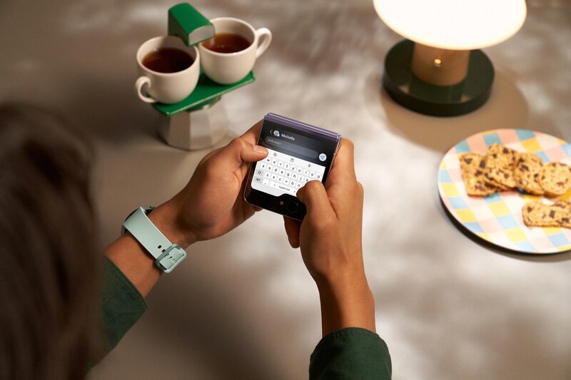 Henkiö kirjoittamassa viestiä Galaxy Z Flip5 puhelimen kansinäytöllä