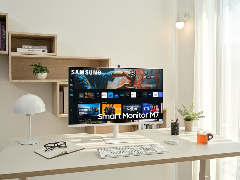 Samsung Smart Monitor M7 pöydällä, jonka edessä on valkoinen näppäimistö ja hiiri