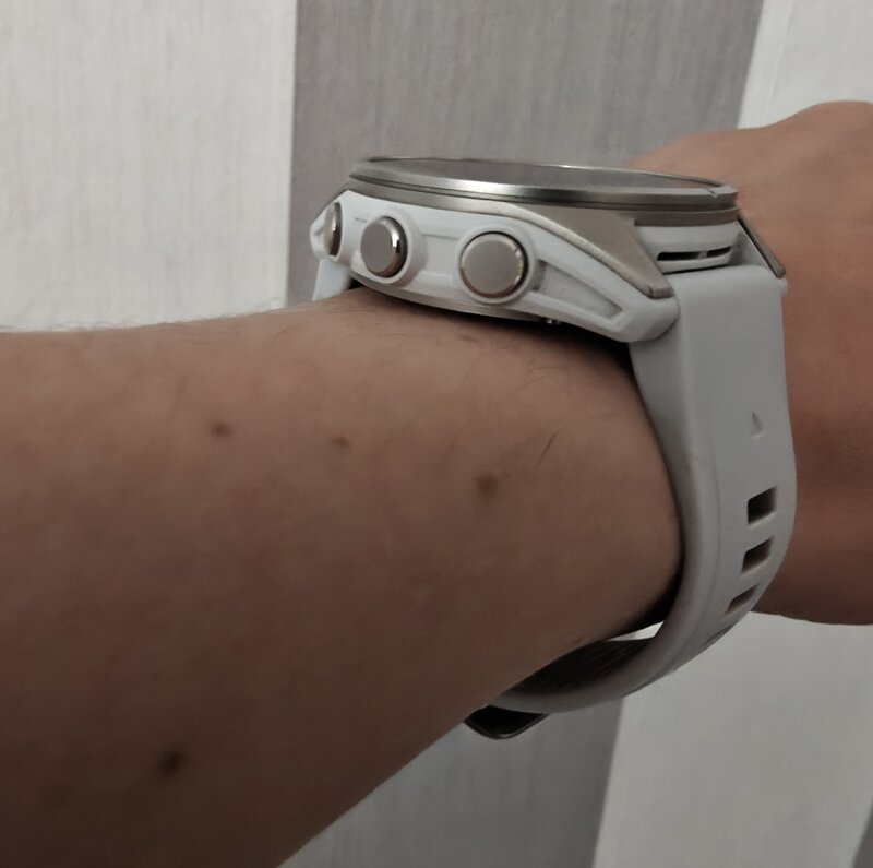 Fenix 8 kädessä, sivusta kuvattuna