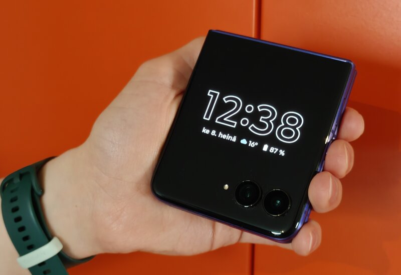 Motorola Razr 70 taitettuna, kädessä, näytöllä kellonaika